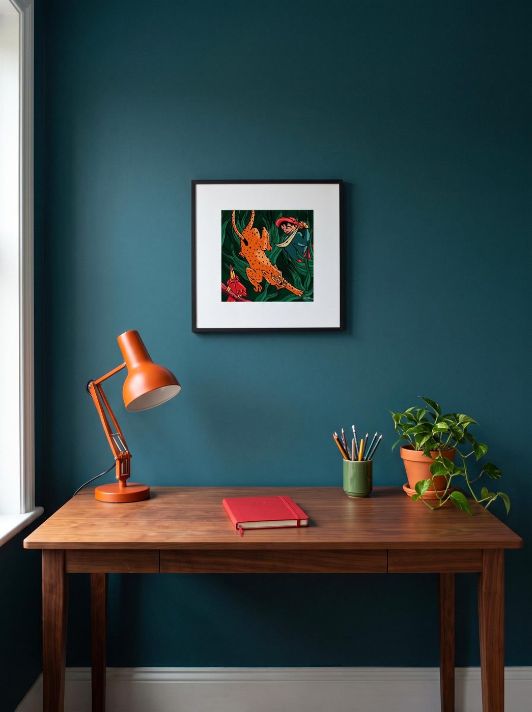 Tableau de la jungle accroché au-dessus d'un bureau, mur bleu canard